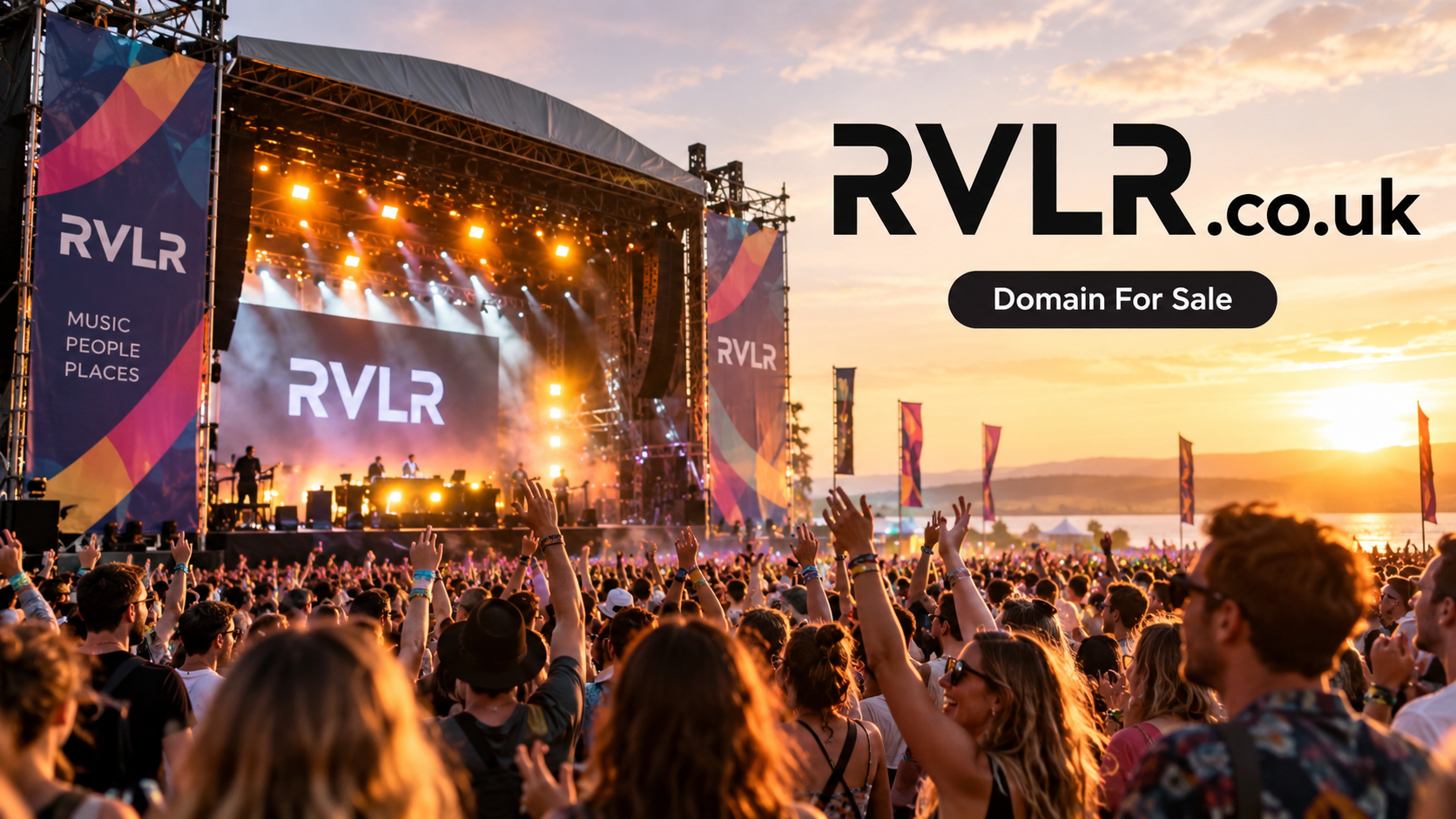 A lively outdoor music festival at sunset, with an illuminated main stage, cheering crowd, colourful event banners and prominent RVLR.co.uk branding beside a Domain For Sale message.